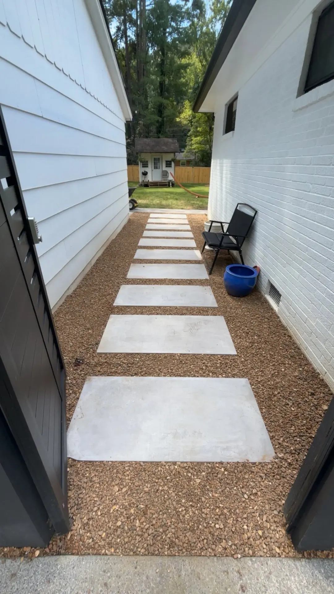 Paver stepping stone walkway set in gravel between two houses
