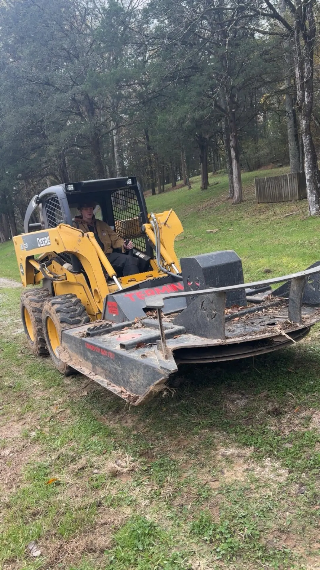 J&W Builds skid steer with brush cutter clearing land on a wooded Tennessee property